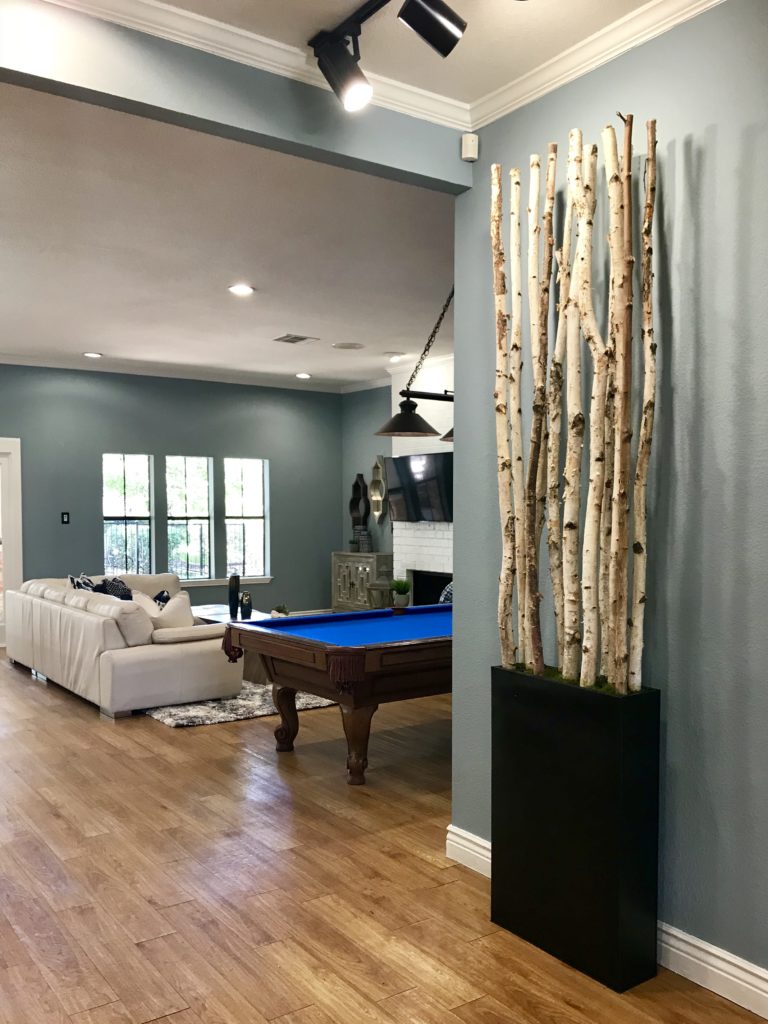 A sneak shot of a game room with a pool table and sofa 