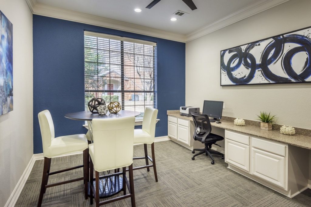 Office setup with chairs, table, counter top and artworks in light grey and neutral tones