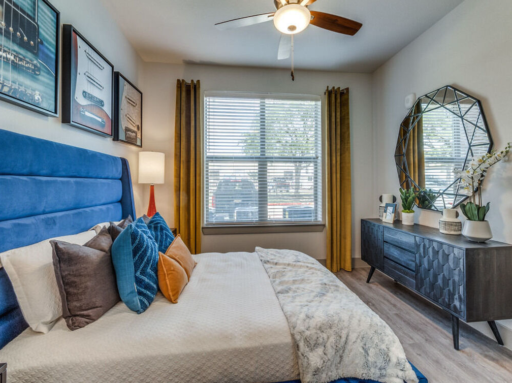Main bedroom with blue velvet bed, guitar artwork in custom model