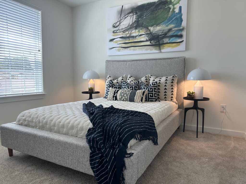 Main bedroom with large art and coordinating fabrics throughout the custom model