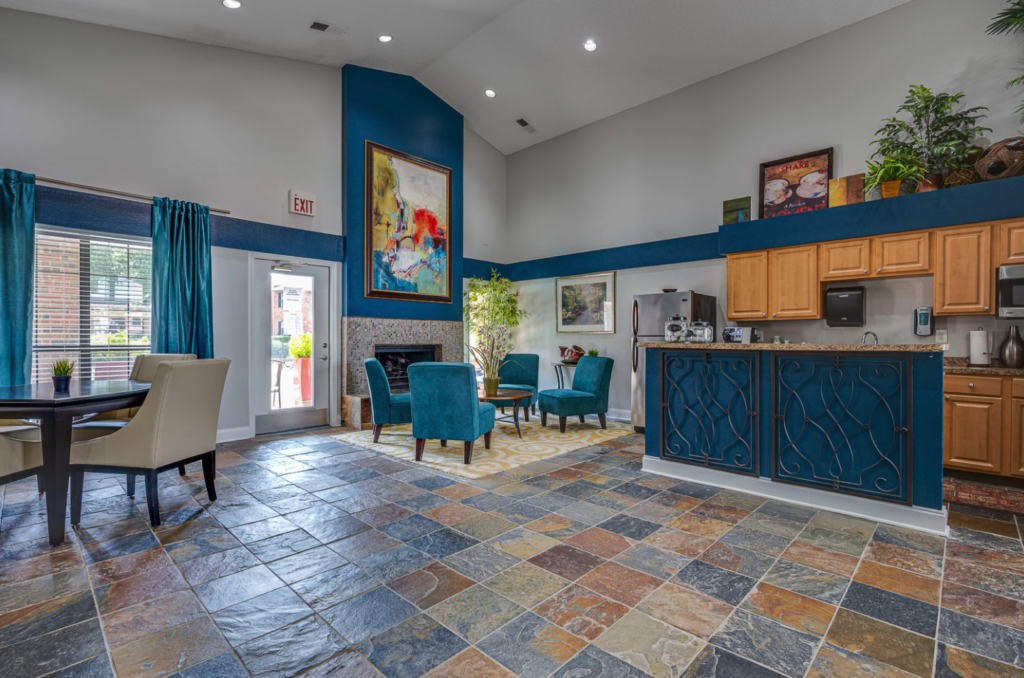 Open kitchen with tile floor, a kitchenette and a seating area in front of a fireplace.