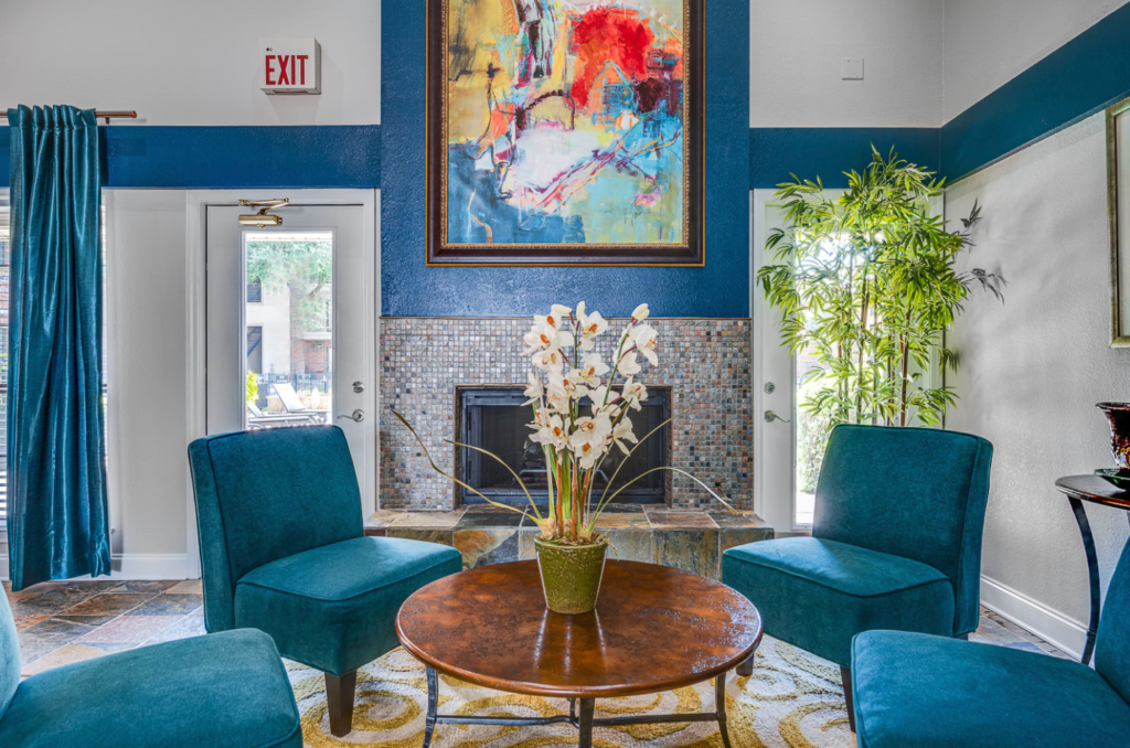 Seating area with blue chairs and a coffee table in front of a fireplace.