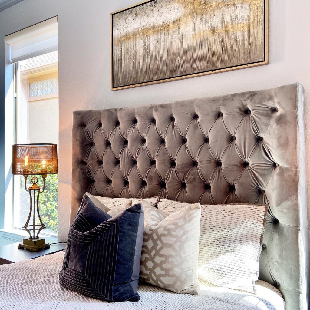 Statement upholstered headboard in light grey and plush pillows
