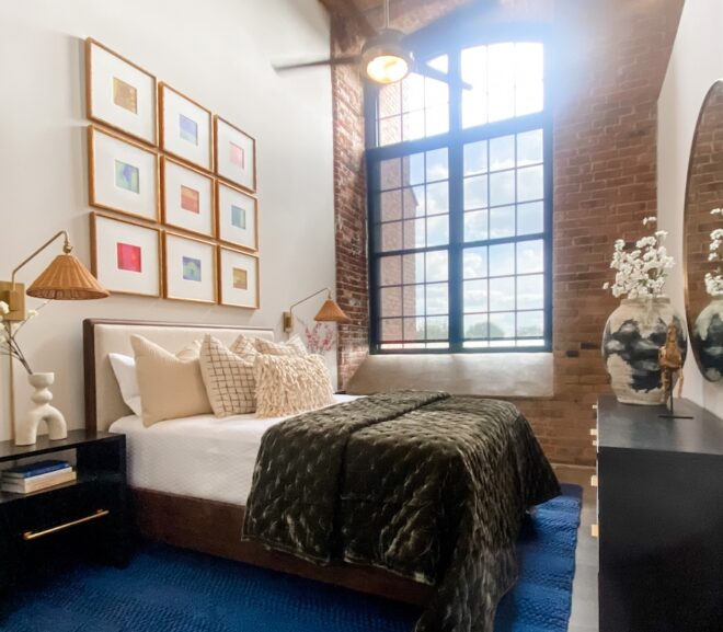 Primary bedroom for Loray Mill Lofts custom model with exposed brick wall and large arched window
