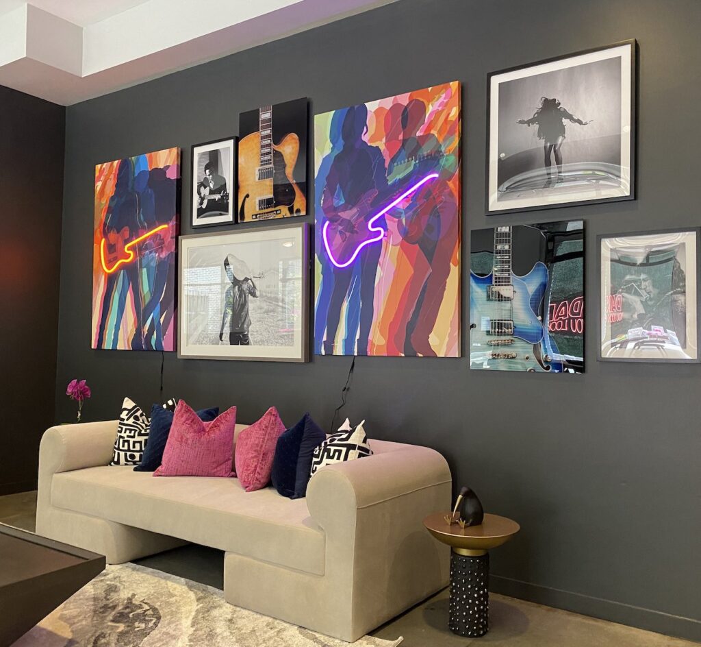Clubroom redesign in Nashville with white sofas and music artwork with neon lights