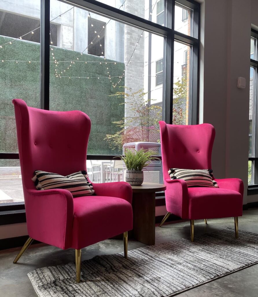 Bright pink chairs for a conversation or coffee in the clubroom redesign