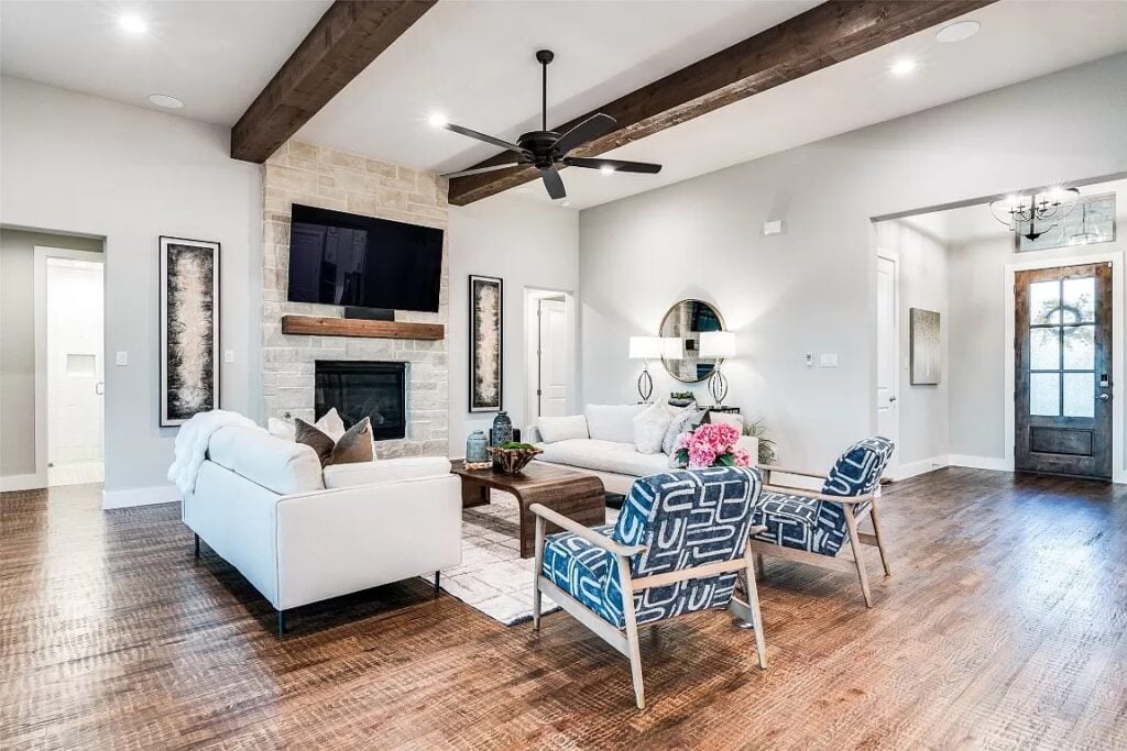 Living room home stage in Dallas with two large white sofas and two blue and white accent chairs.