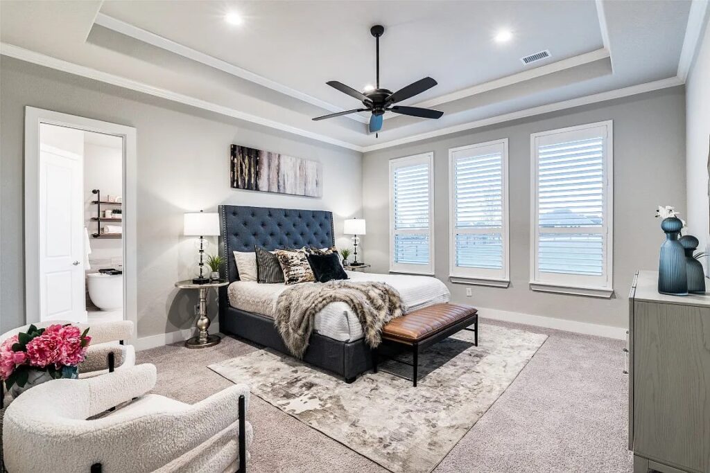 Home Staging Dallas Fort Worth of a master bedroom with luxury bedding a cozy seating area