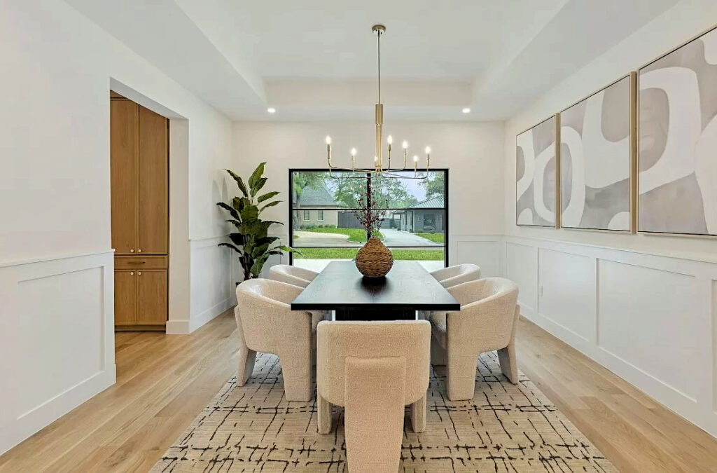 Staging of dining room with large rectangular table and six plush dining chairs