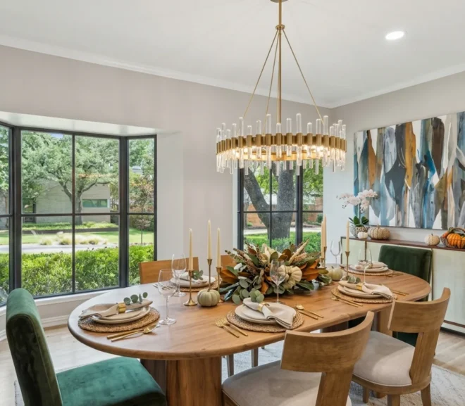 Thanksgiving dining room table with table settings, pumpkin decor and tall elegant candles