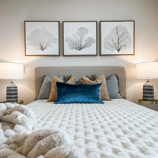 Bed with decorative pillows and artwork above the headboard