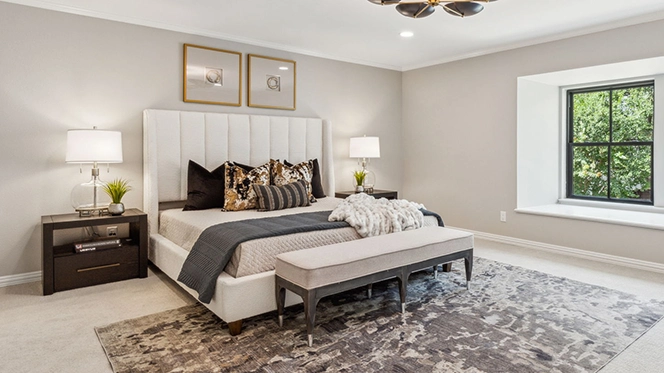 White upholstered bed with black, gold and white pillows