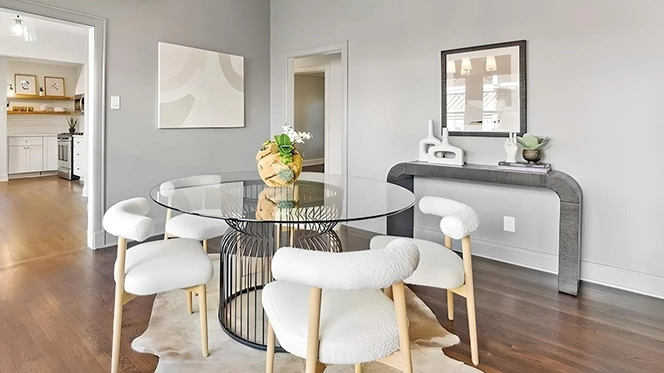 Slim grey console table in dining room with white vases and small abstract artwork