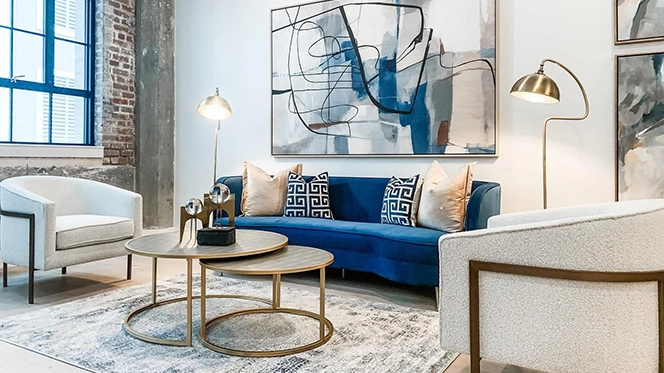 Elegant living room furniture with blue velvet sofa and two white chairs with gold accents