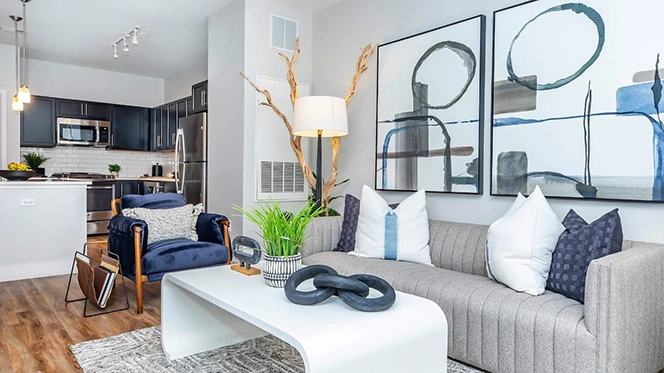Livng room with a soft color palette of greys, whites & blues including a grey modern sofa and white coffee table