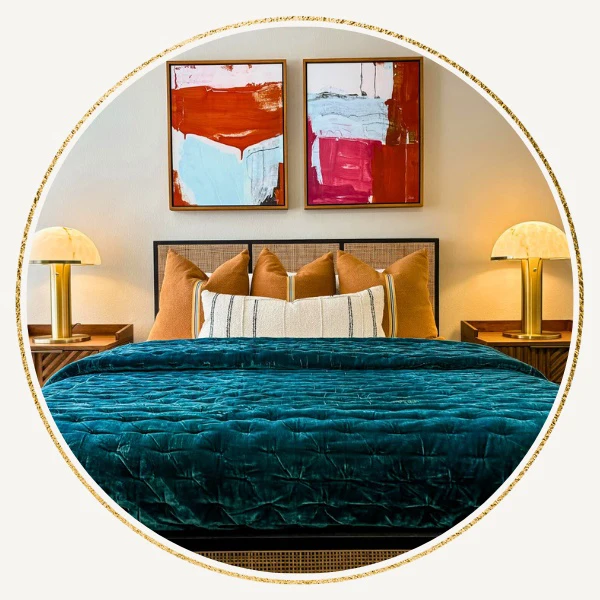 Closeup of green sofa with gold, black & white pillows and large abstract artwork