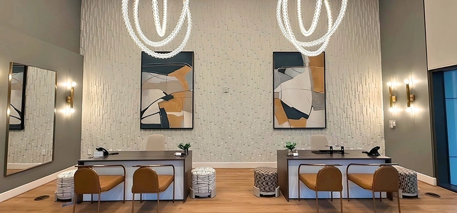 Leasing area with two modern desks, tan leather guest charirs and large abstract artwork with black, tan and grey colors