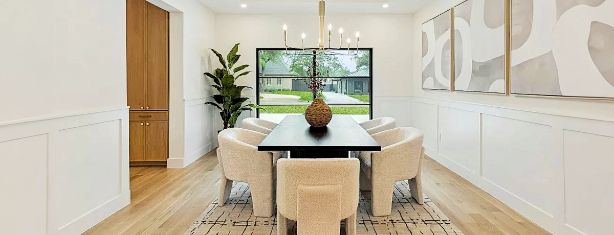 Dining room with large rectangular table and six off white upholstered chairs