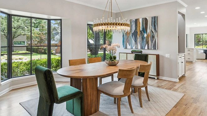 Modern light colored wood rectangular dining table with four matching side chairs and two velvet green end chairs