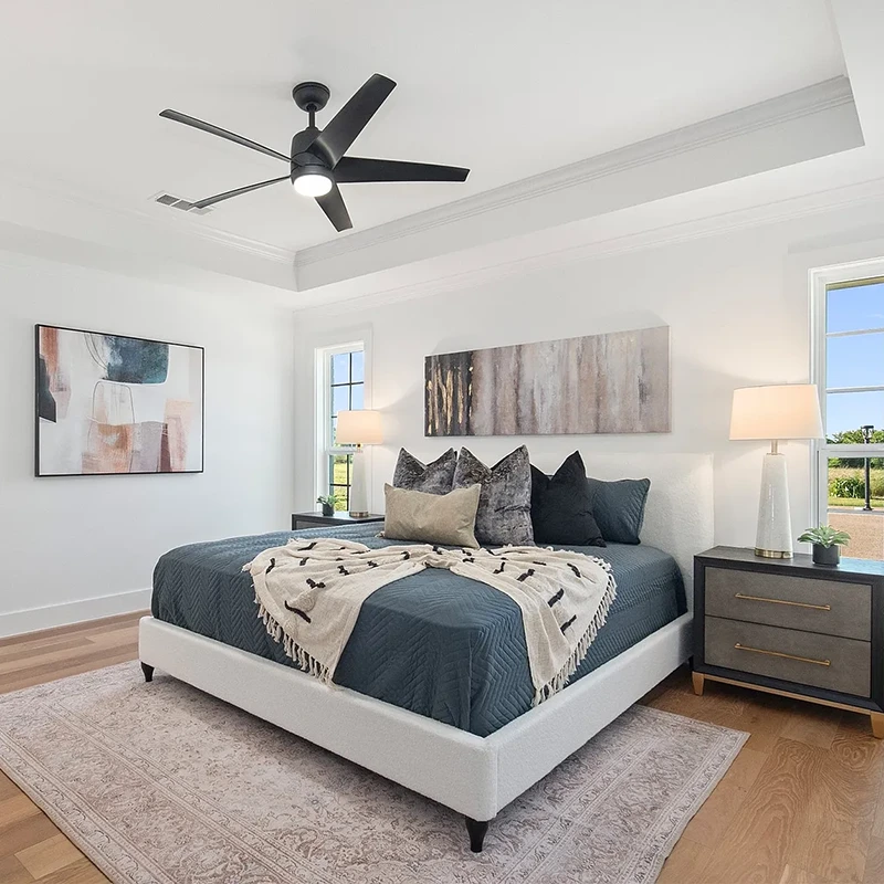 Bedroom with white upholstered bedding, blueish grey bedding and black pillows