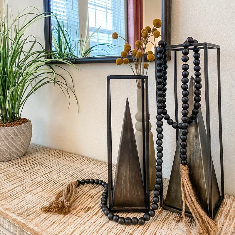 Home decor elements sitting on top of a dresser with greenery