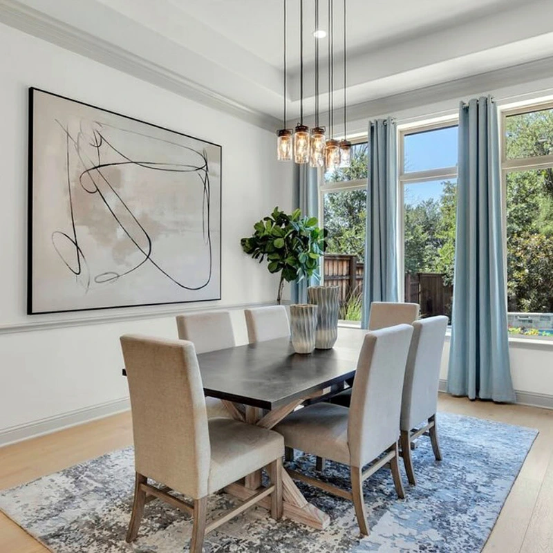 Dining room with large rectangular wooden table, six high back upholstered chairs, large tan and black abstract painting