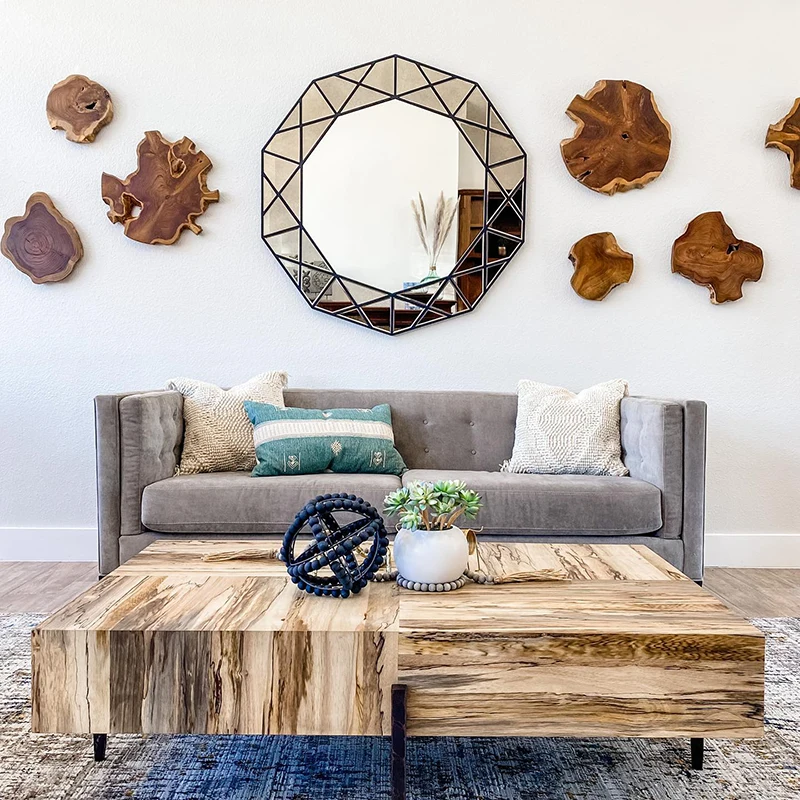 Grey sofa, large wooden grain coffee table, large round mirror and wooden handing accent pieces