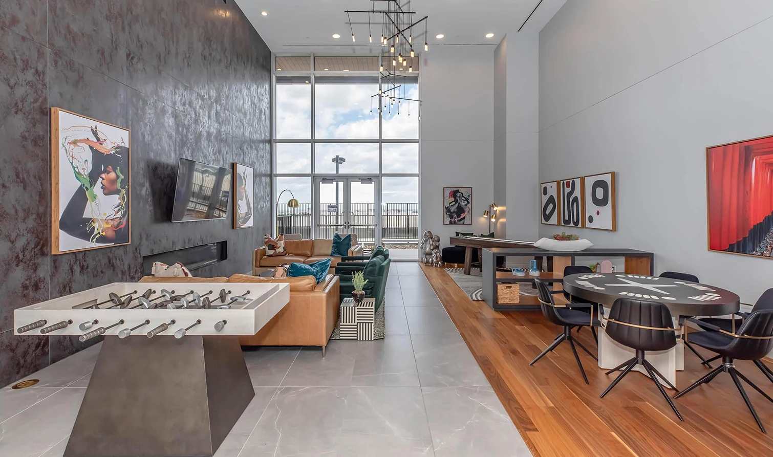 Modern game room with table games, multiple sofas and artwork on the walls
