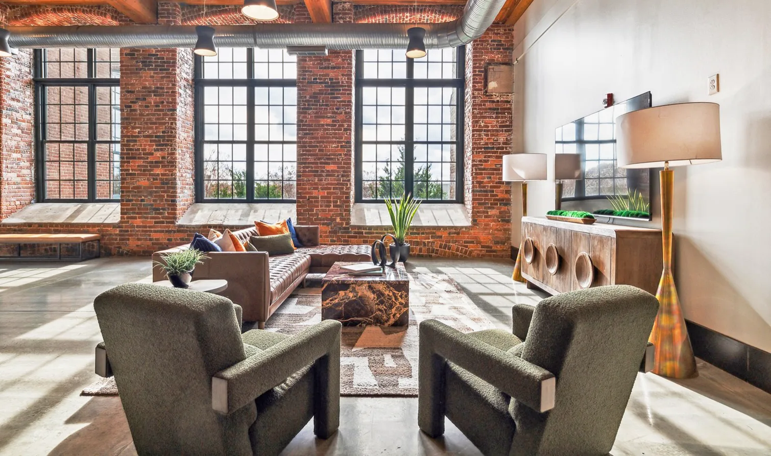 Urban living room with brick walls, a leather sofa, a coffee table and chairs