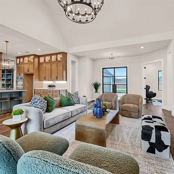 Living Room styled with grey sofa with green pillows, two green accent chairs and cowhide ottomans