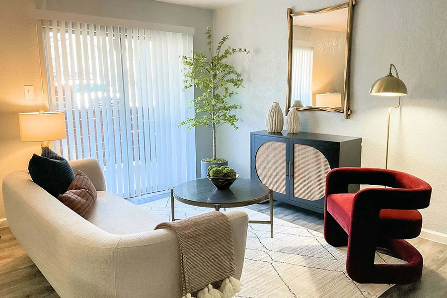 District ModelEasy living room styled with white sofa, burgundy chair.