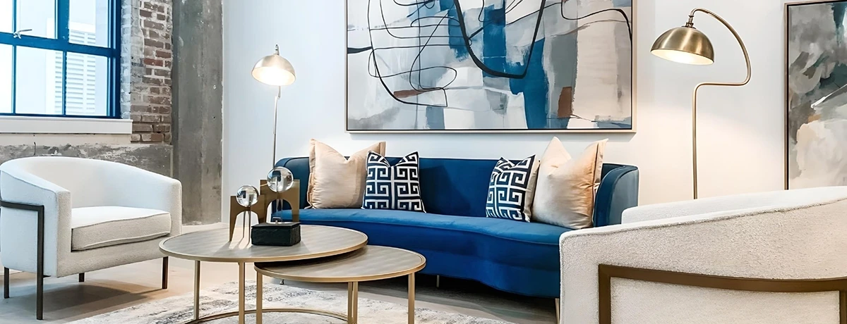 Elegant living room furniture with blue velvet sofa and two white chairs with gold accents