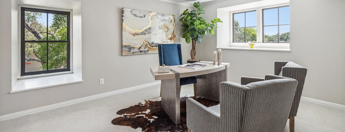 Home office with modern grey desk, blue desk chair and two accent chairs