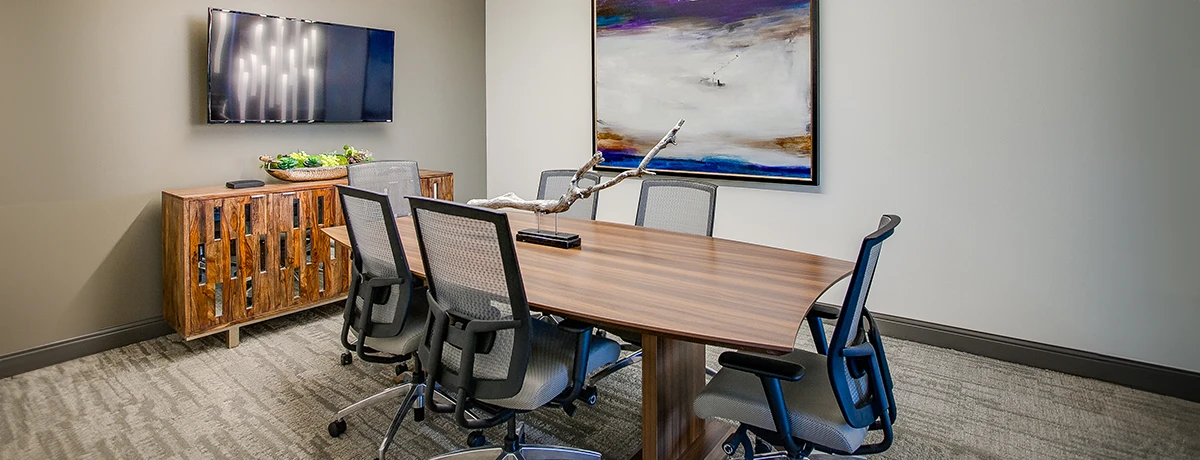 Conference room with large rectangular executive table, mesh high back executive chairs, large abstract artwork