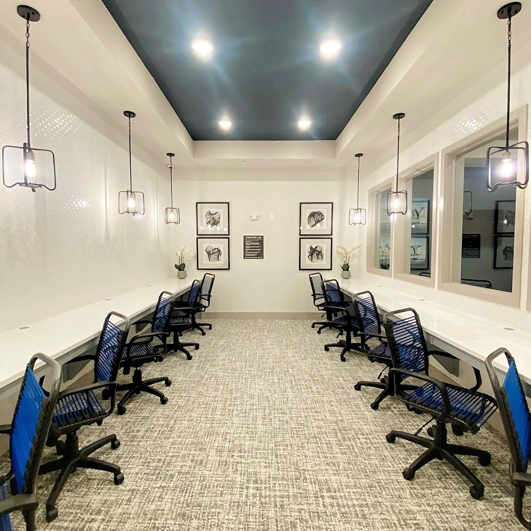 Large business center with ten blue and black task chairs, black and white abstract artwork