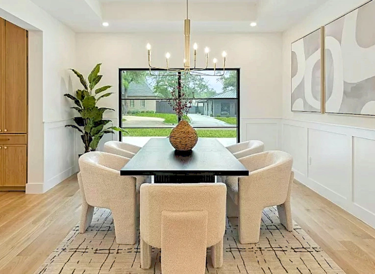 Dining room with large rectangular table and six off-white velvet chairs