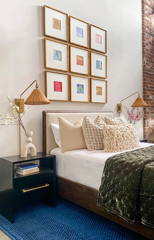 Bedroom with loft ceilings and luxurious bedding with pops of color in artwork